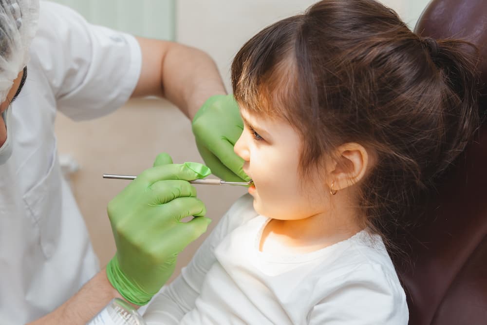 dentist examins girl's teeth