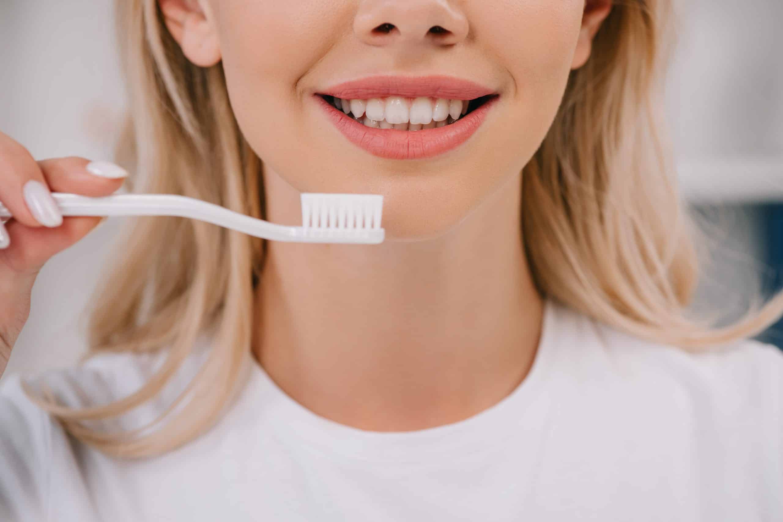 woman smiling holding toothbrush